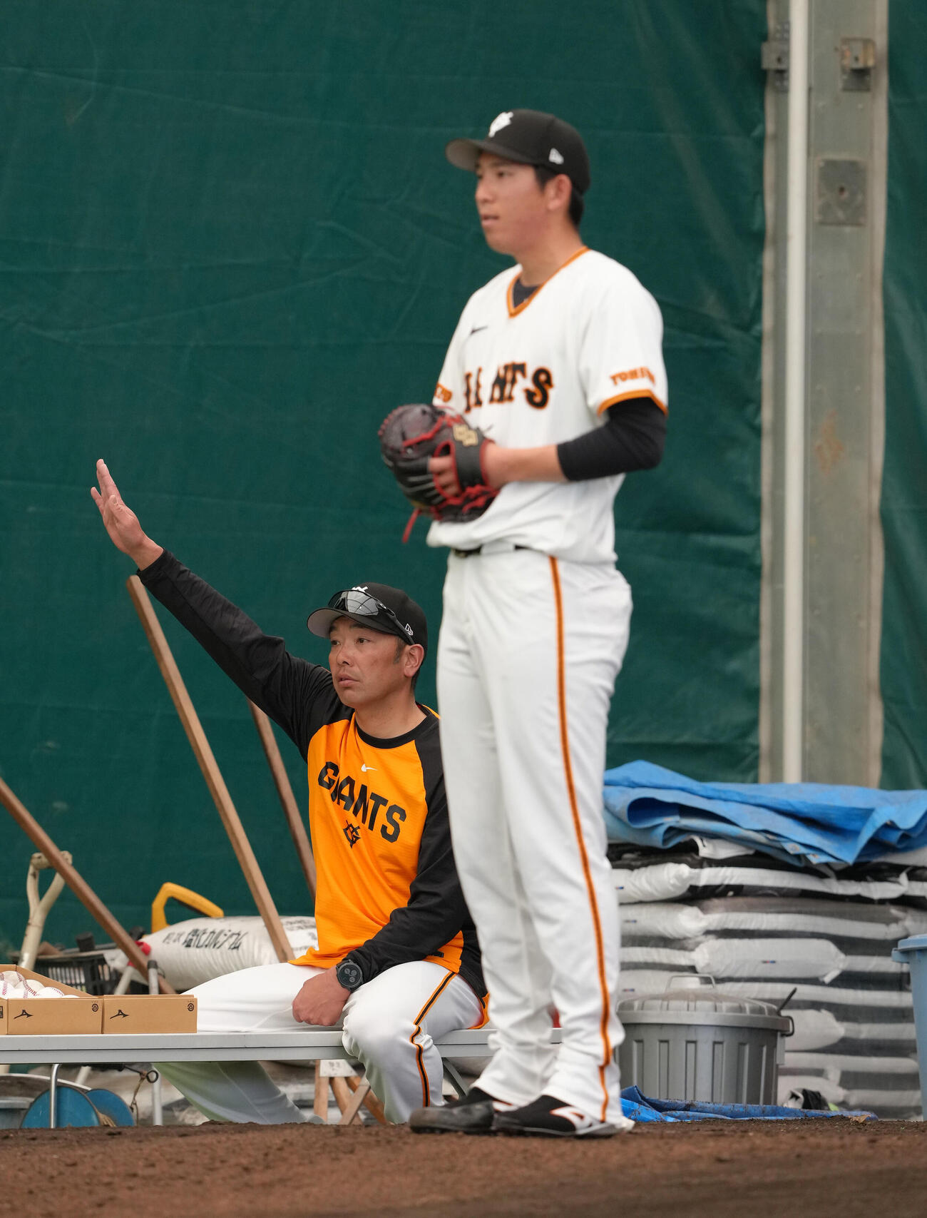 ブルペン投球する巨人戸郷（右）を指導する阿部監督（撮影・足立雅史）