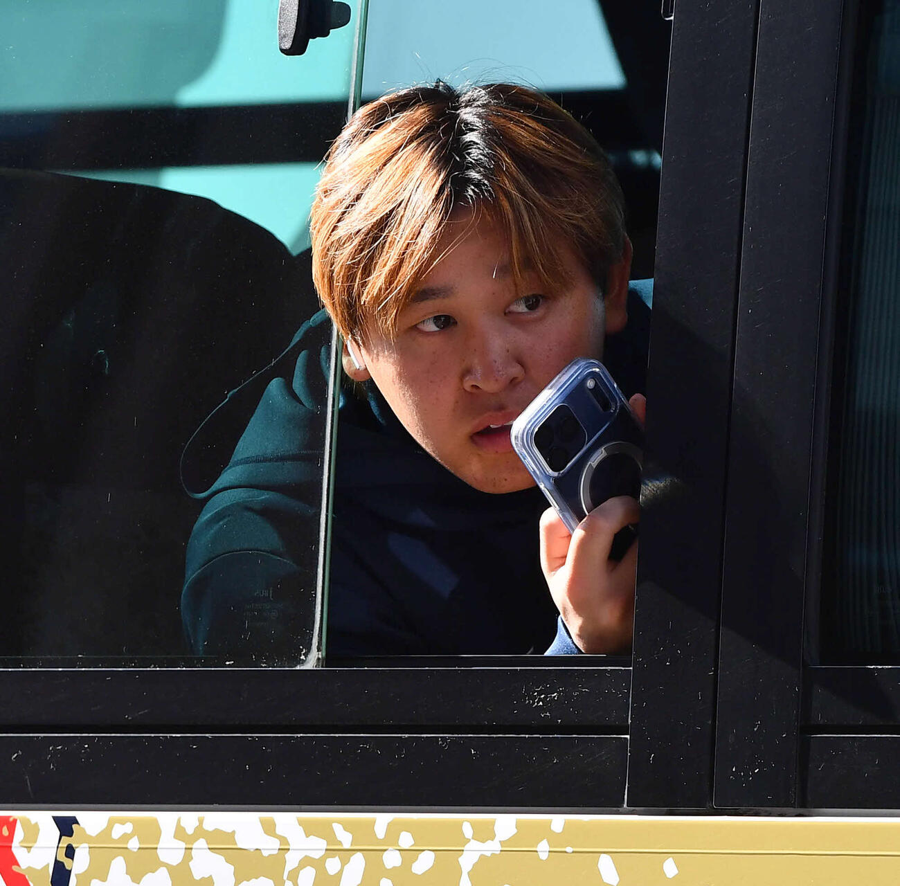 帰宿バスの中から侍ジャパン公式マスコットのたまベヱを撮影する宮城（撮影・岩下翔太）