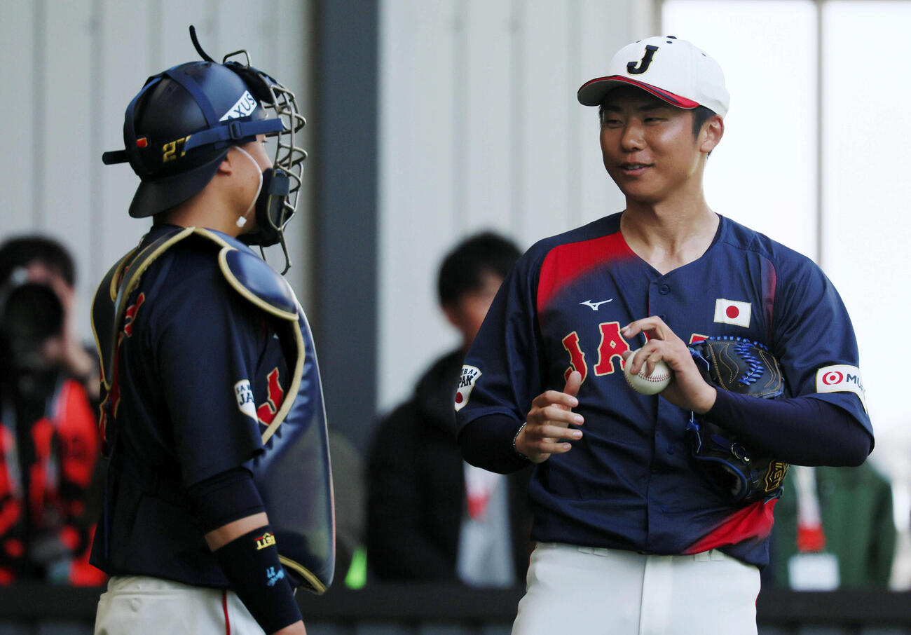 ブルペンでの投球練習を終え中村悠（左）と話す侍ジャパン曽谷（撮影・加藤哉）