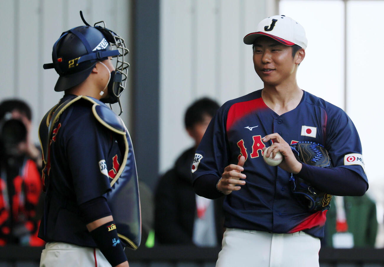 ブルペンでの投球練習を終え中村悠（左）と話す侍ジャパン曽谷（撮影・加藤哉）