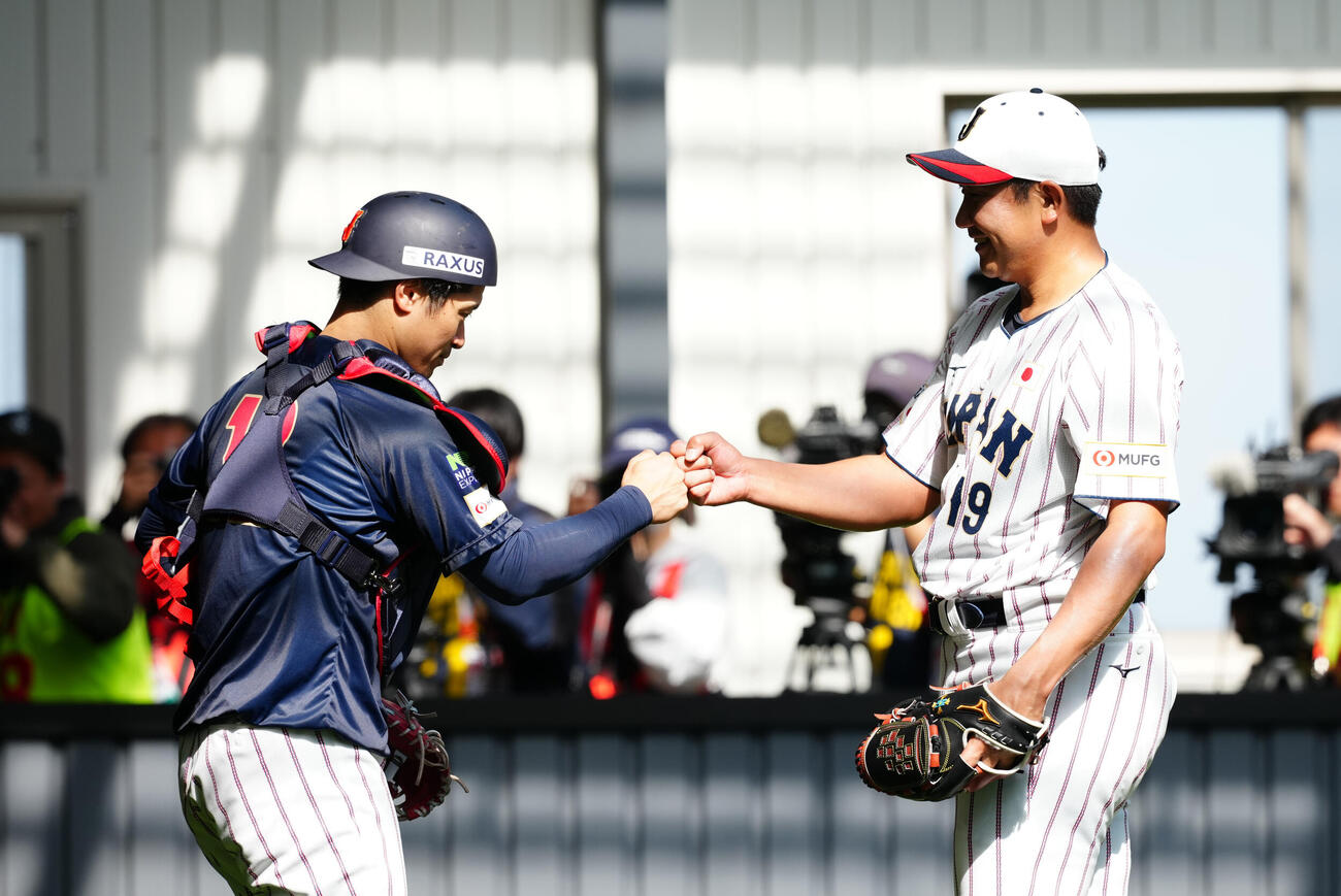 ブルペン投球を終えグータッチを交わす菅野（右）と坂本（撮影・垰建太）