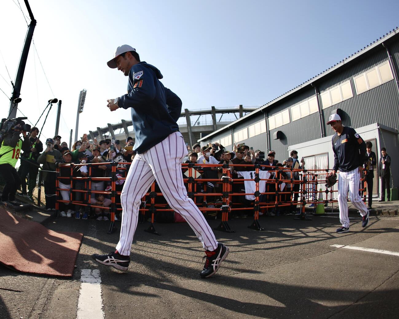グラウンドに移動するアドバイザーのダルビッシュ（左）と菅野（撮影・河田真司）