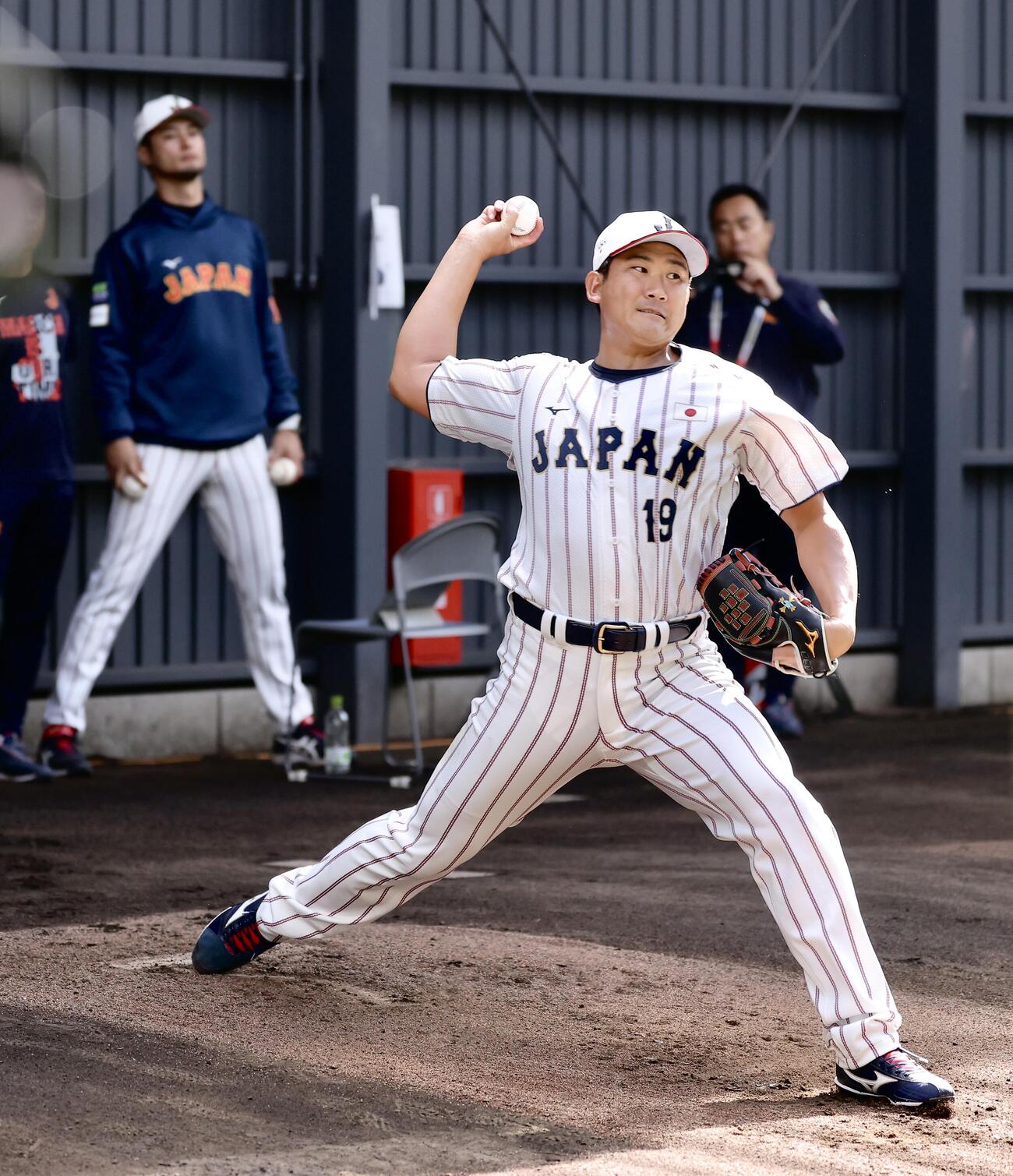 ブルペン投球する菅野。後方左はアドバイザーのダルビッシュ（撮影・河田真司）