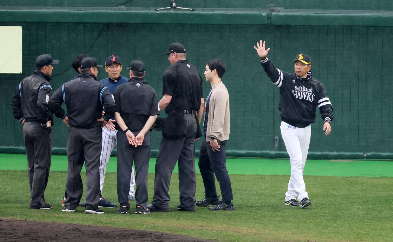 日本対ソフトバンク　7回裏を前に降雨コールド試合となり選手に声をかけるソフトバンク小久保監督（右）と審判団と話し合う侍ジャパン井端監督（撮影・加藤哉）