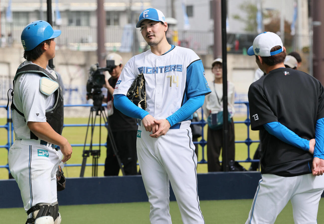 日本ハム対広島　ブルペンで投げた有原航平（中央）と武田久投手コーチ（右）（撮影・加藤孝規）