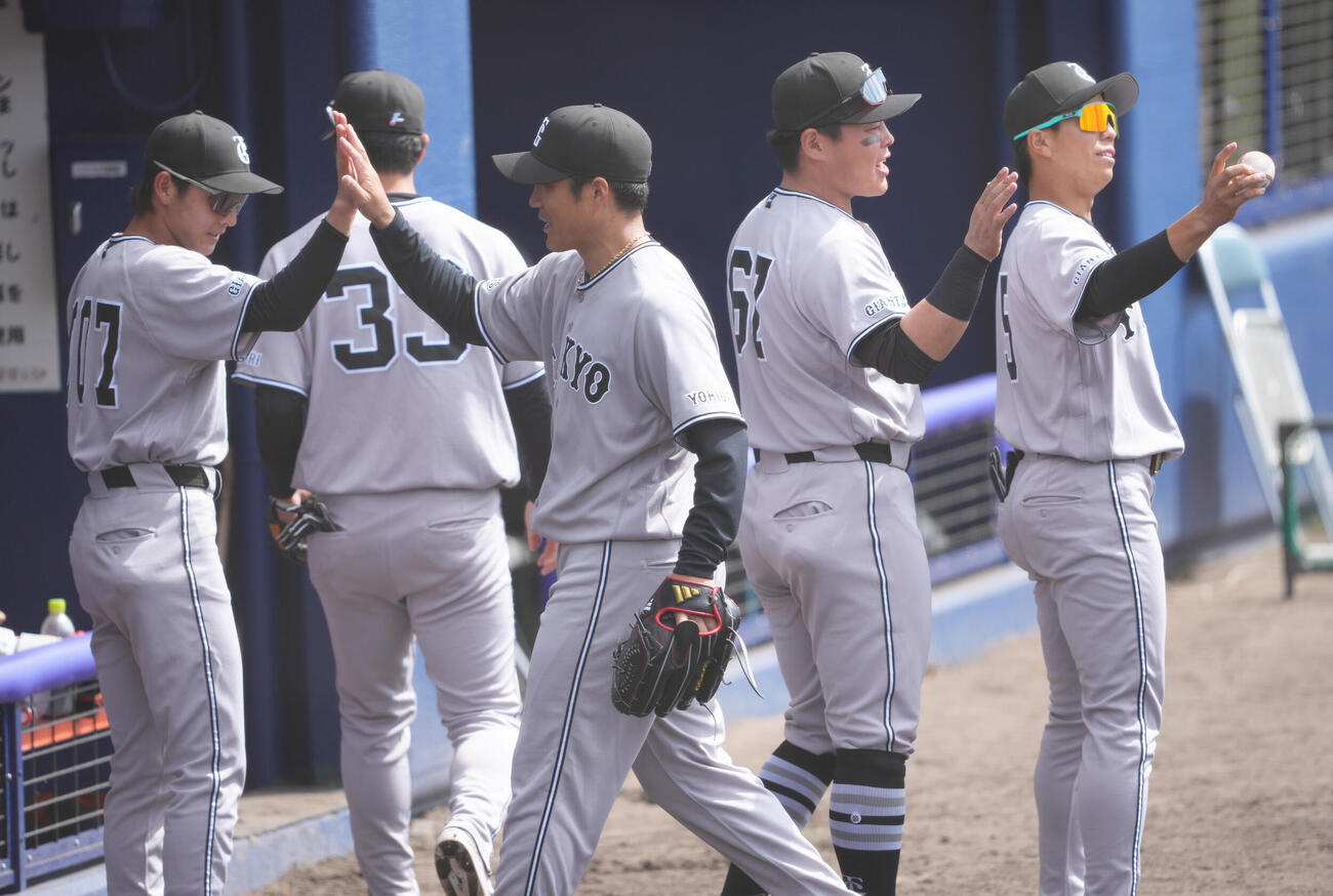 中日対巨人　1回裏　中日の攻撃を無安打に抑えた巨人先発の則本（中央）はナインにタッチで迎えられる（撮影・足立雅史）