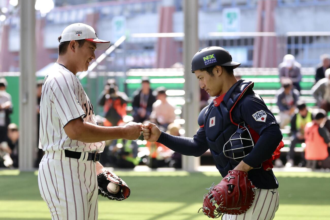 ブルペン投球を終えグータッチを交わす菅野（左）と坂本（撮影・河田真司）