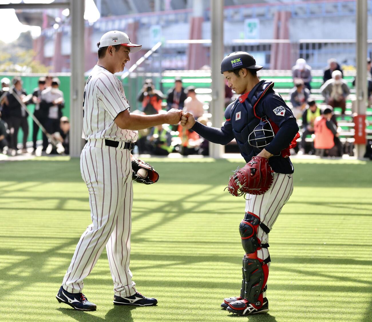 ブルペン投球を終えグータッチを交わす菅野（左）と坂本（撮影・河田真司）