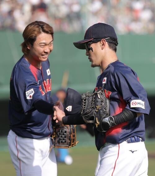 日本対ソフトバンク 5回裏を終え、高橋(左)に迎えられる牧原(撮影・河田真司)