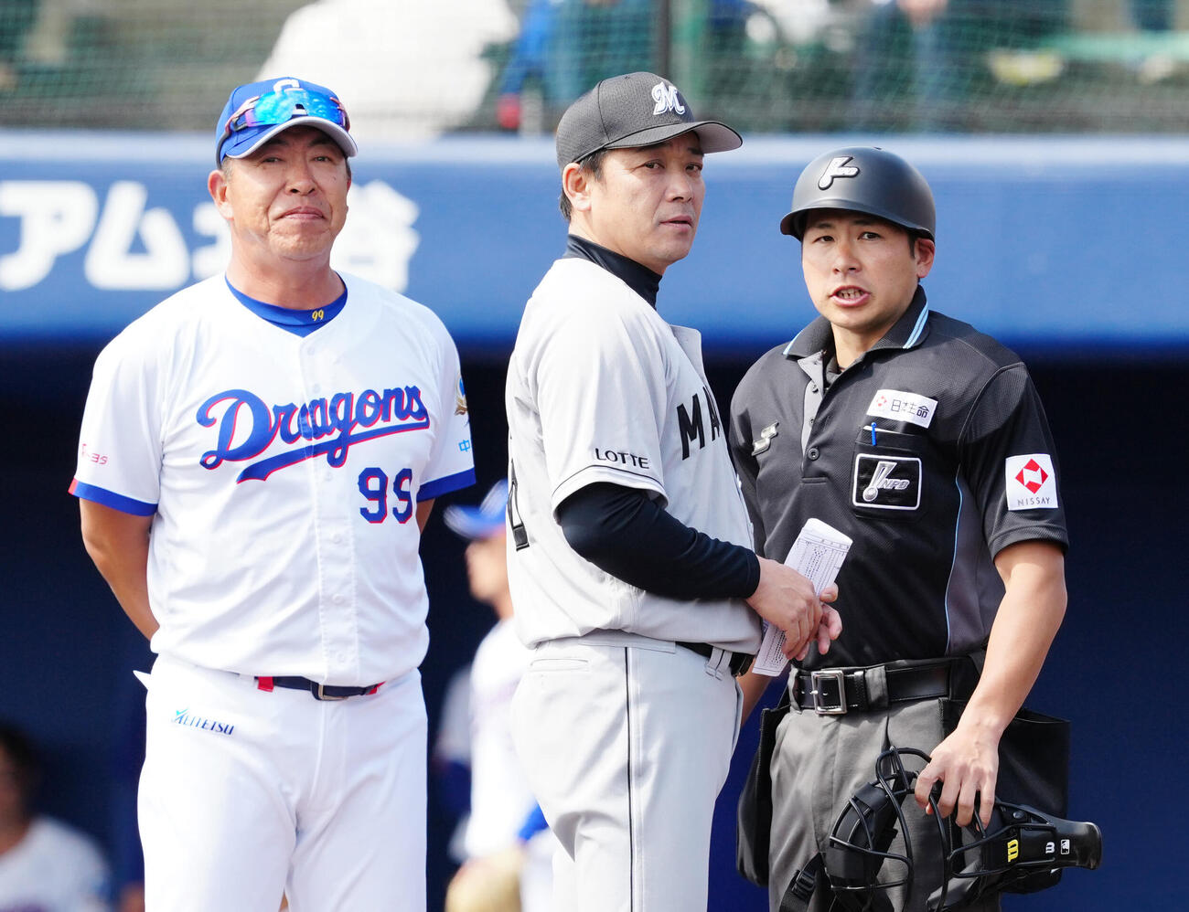 中日対ロッテ　試合前、メンバー表の最終確認を行うロッテ・サブロー監督（中央）と中日井上監督（左）（撮影・江口和貴）