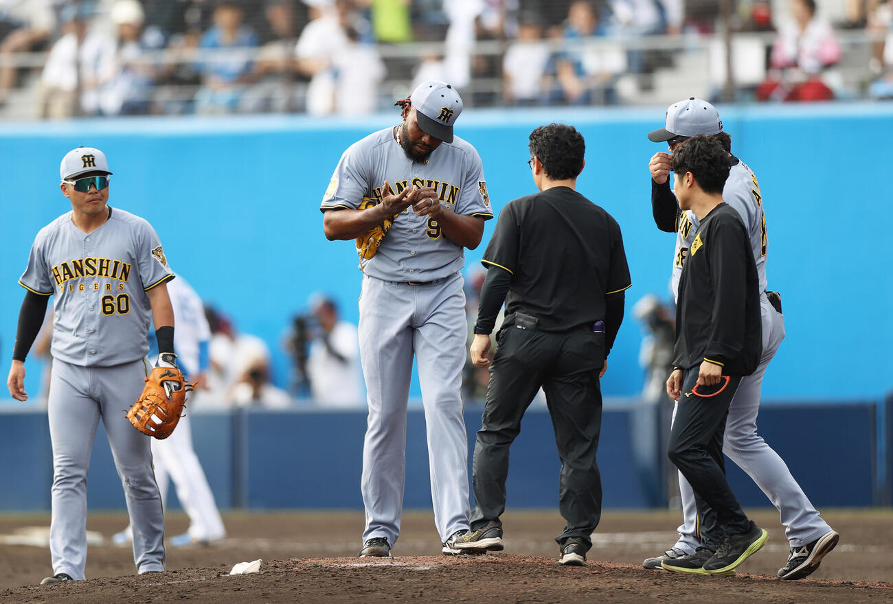 オープン戦　日本ハム対阪神　8回裏日本ハム1死、ドリス（左から2人目）は代打藤森を投ゴロに仕留めるが右手を気にする（撮影・上山淳一）