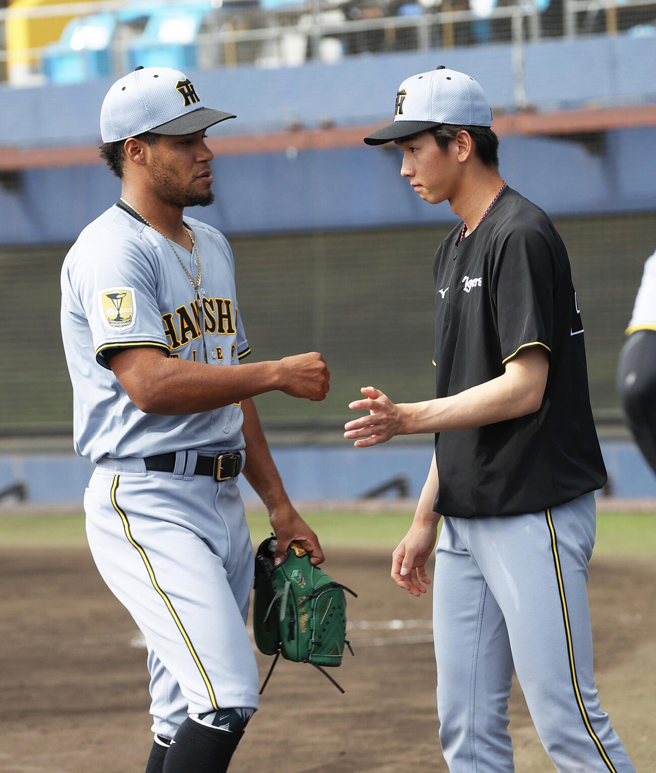 オープン戦　日本ハム対阪神　6回裏に登板したモレッタ（左）は無失点に終えベンチ前で今朝丸から出迎えられる（撮影・上山淳一）