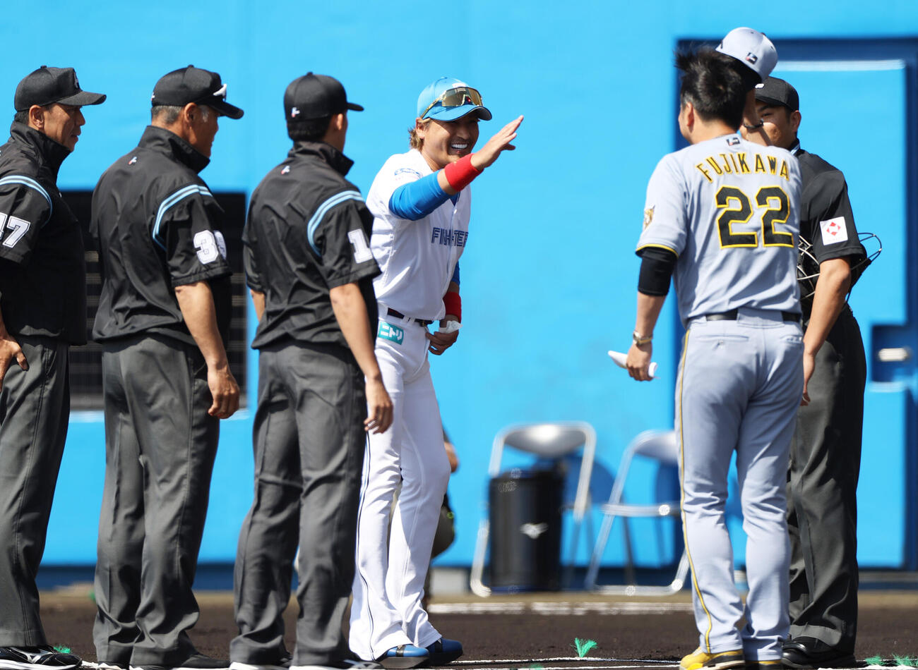 オープン戦　日本ハム対阪神　メンバー確認で言葉をかわす阪神藤川監督（手前）と日本ハム新庄監督（撮影・上山淳一）