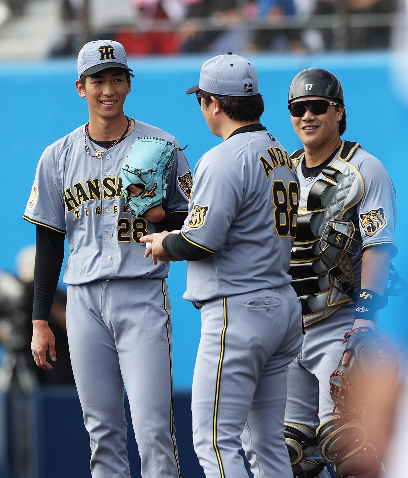 日本ハム対阪神　4回裏日本ハム無死、今朝丸（左）はレイエスを空振り三振に仕留め交代となり、安藤投手チーフコーチ（手前）から声をかけられ笑顔を見せる。右は捕手伏見（撮影・上山淳一）