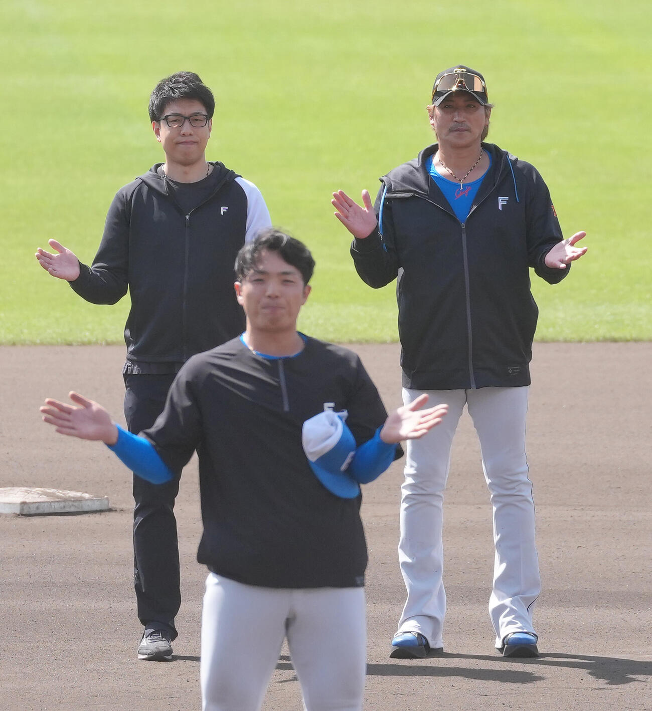 名護キャンプを打ち上げ手締めする日本ハム郡司（手前）。右は新庄監督（撮影・足立雅史）