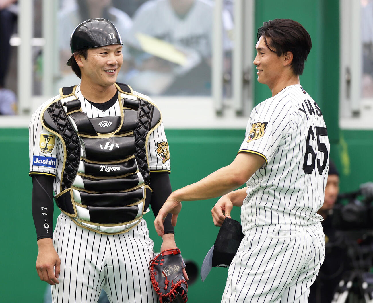 ブルペンで投球を終えた阪神湯浅（右）と笑顔で話す伏見（撮影・上山淳一）