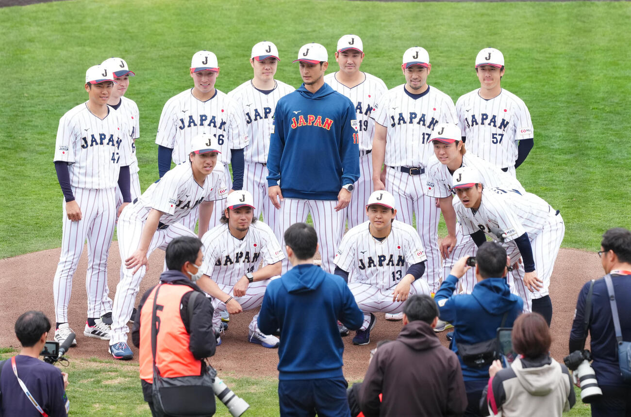 練習後にアドバイザーのダルビッシュ（中央）を囲み写真に納まる投手陣（撮影・垰建太）