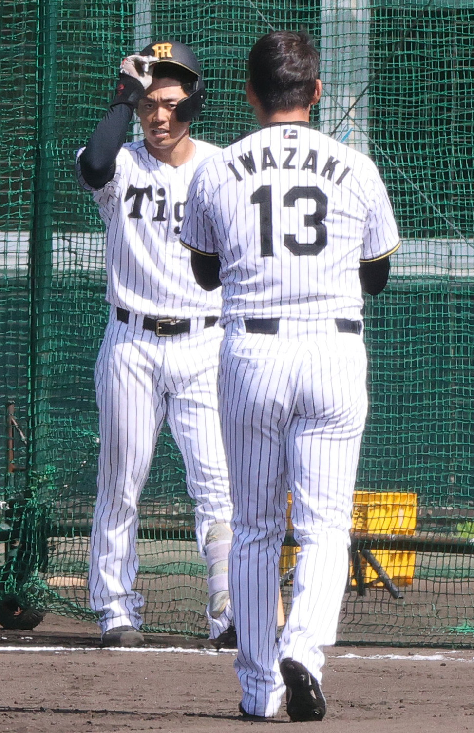 ライブBPで登板した阪神岩崎（手前）にあいさつする谷端（撮影・上山淳一）