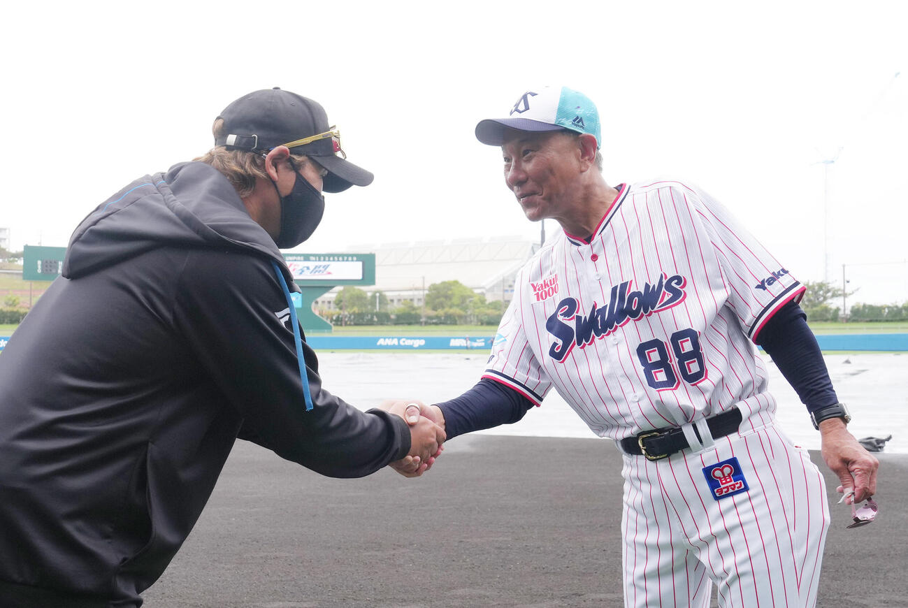 練習中、握手を交わす日本ハム新庄監督（左）とヤクルト池山監督（撮影・足立雅史）