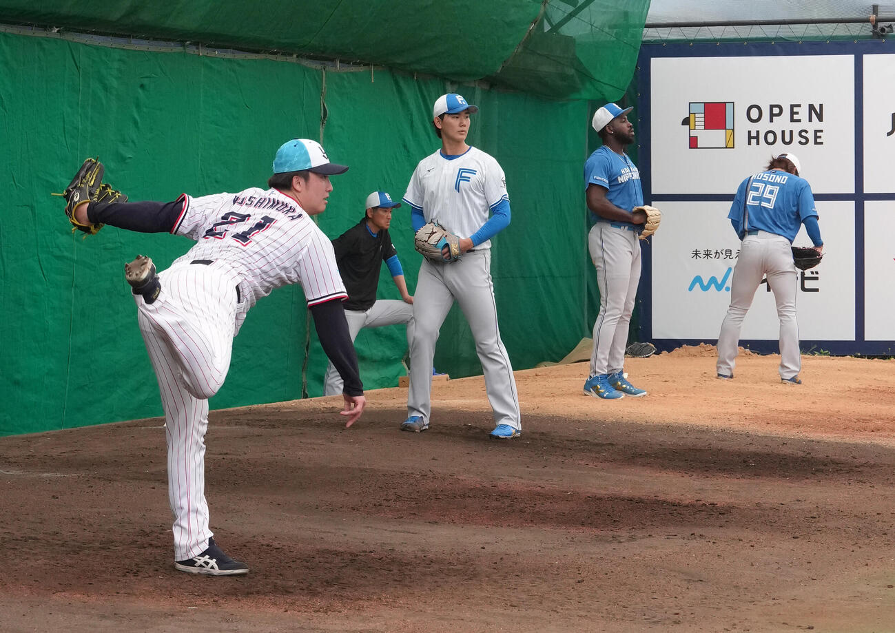 日本ハムの選手たちと並んでブルペン投球するヤクルト吉村（左端）（撮影・足立雅史）