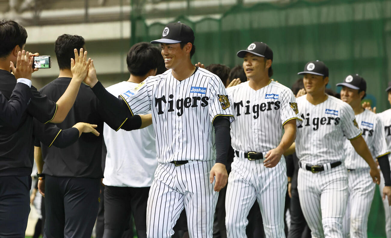 キャンプを終えた谷端将伍はスタッフと笑顔でハイタッチをする（撮影・上田博志）