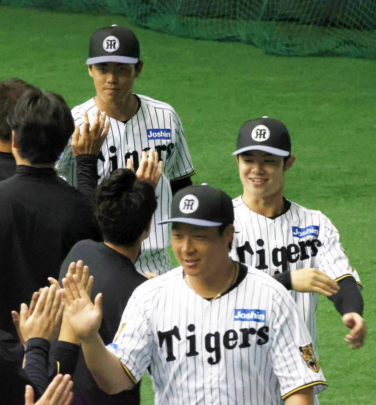 宜野座キャンプを打ち上げスタッフらとタッチをかわす、左から阪神谷端、大山、中野（撮影・上山淳一）