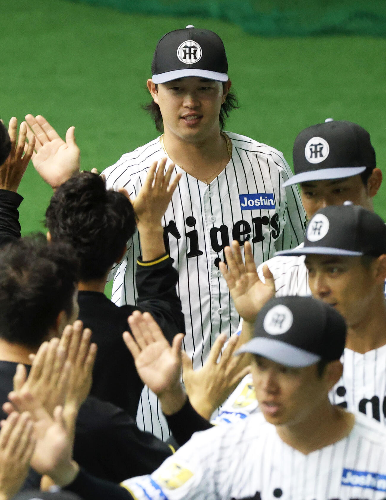 宜野座キャンプを打ち上げスタッフらとタッチをかわす阪神浜田（撮影・上山淳一）