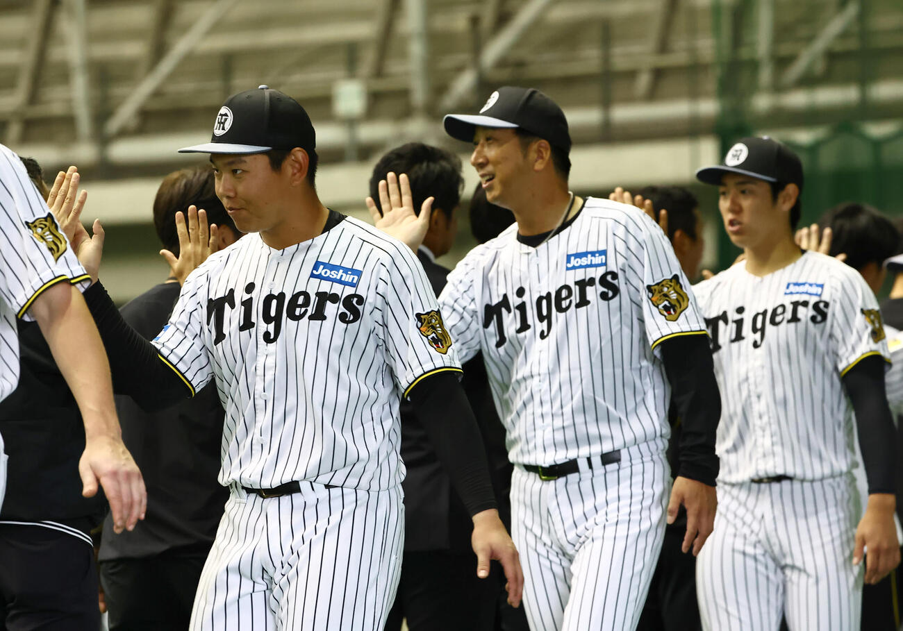キャンプを終えた左から嶋村、藤川監督、石黒はスタッフとハイタッチする（撮影・上田博志）