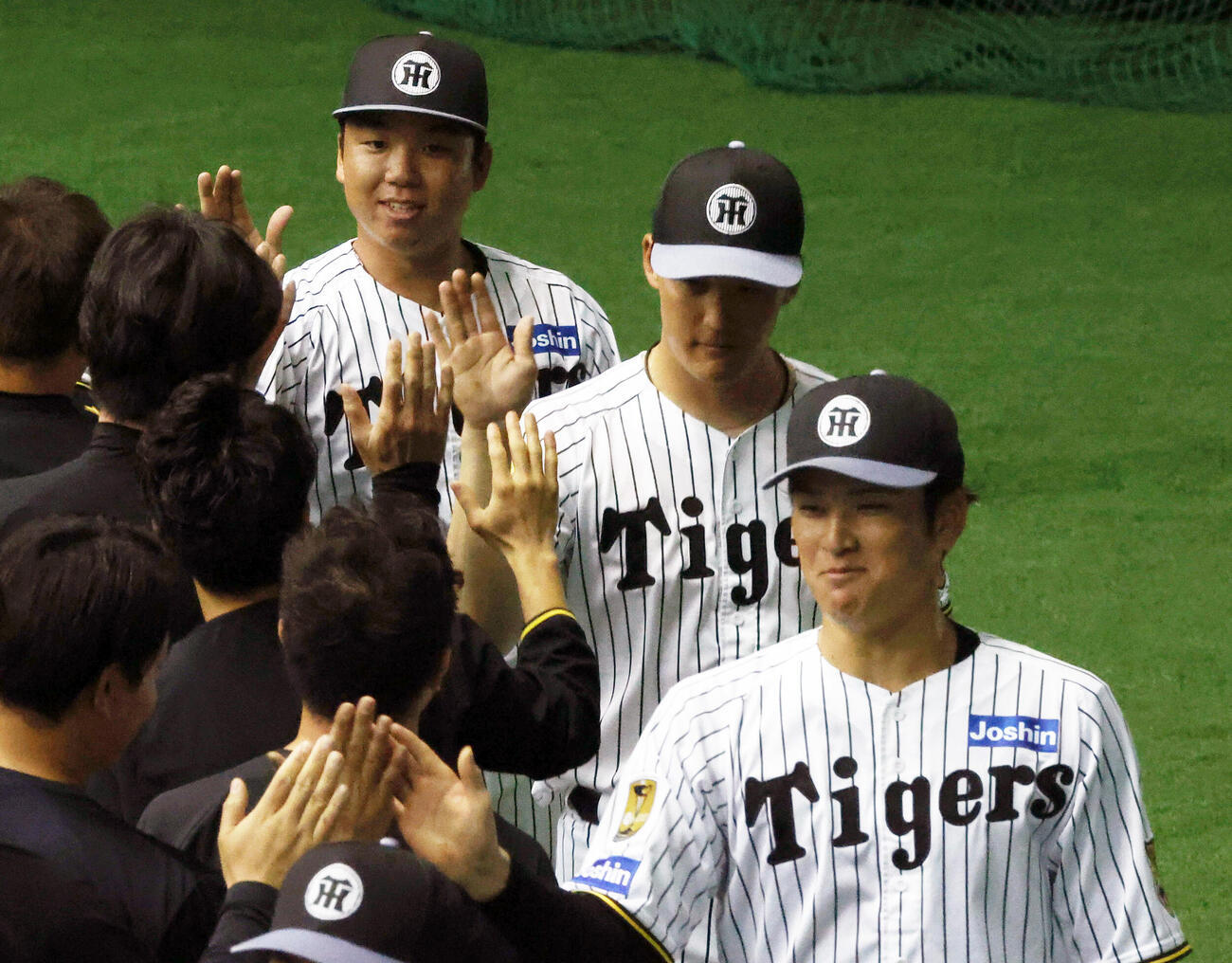 宜野座キャンプを打ち上げスタッフらとタッチをかわす、左から阪神村上、元山、高寺（撮影・上山淳一）