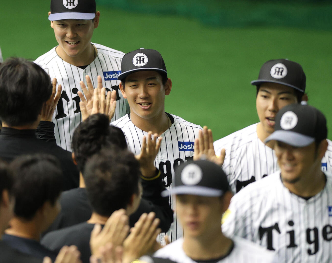 宜野座キャンプを打ち上げスタッフらとタッチをかわす阪神伊原（左から2人目）（撮影・上山淳一）