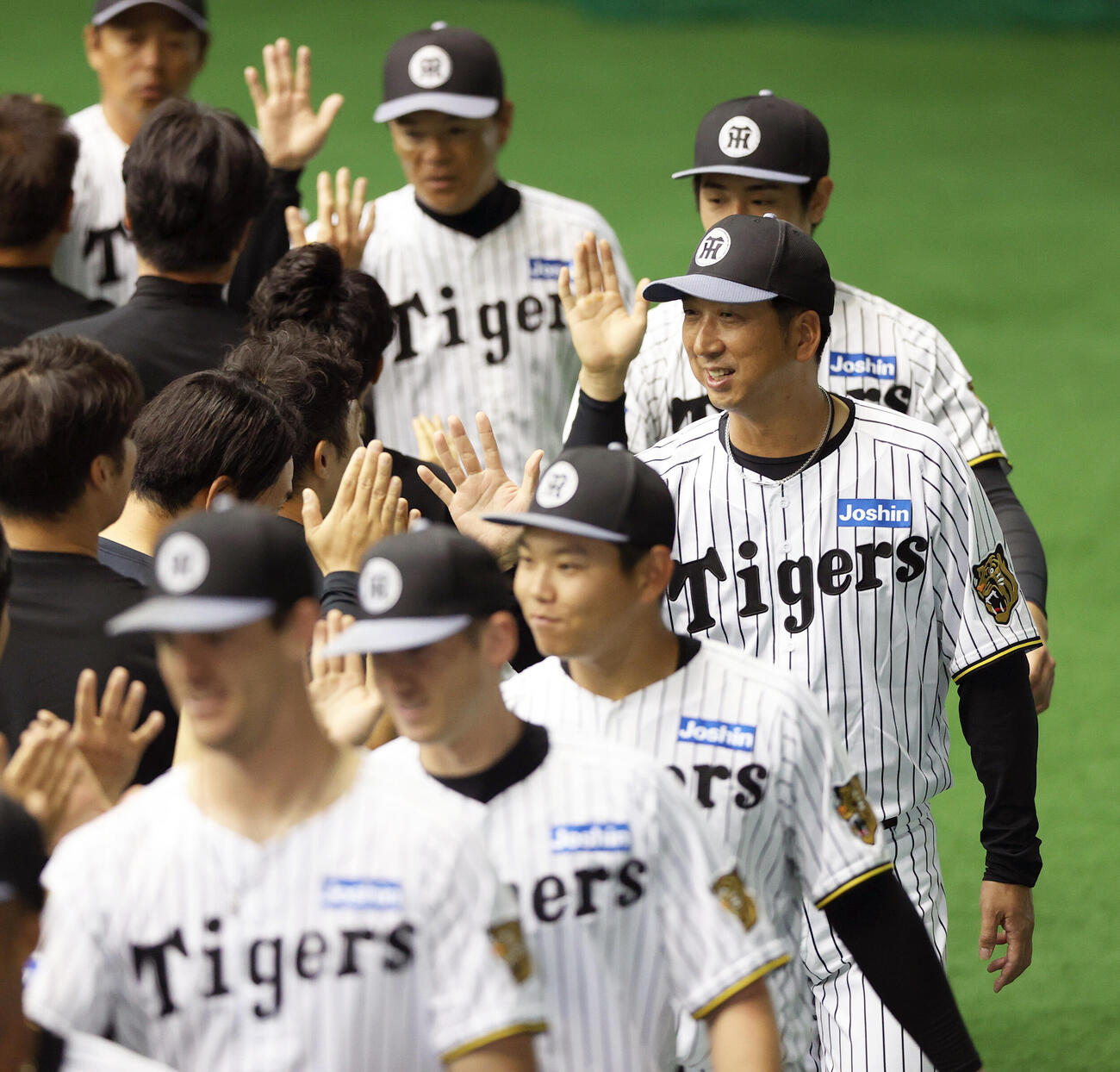 阪神藤川監督（右）は宜野座キャンプを打ち上げスタッフらと笑顔でタッチをかわす（撮影・上山淳一）