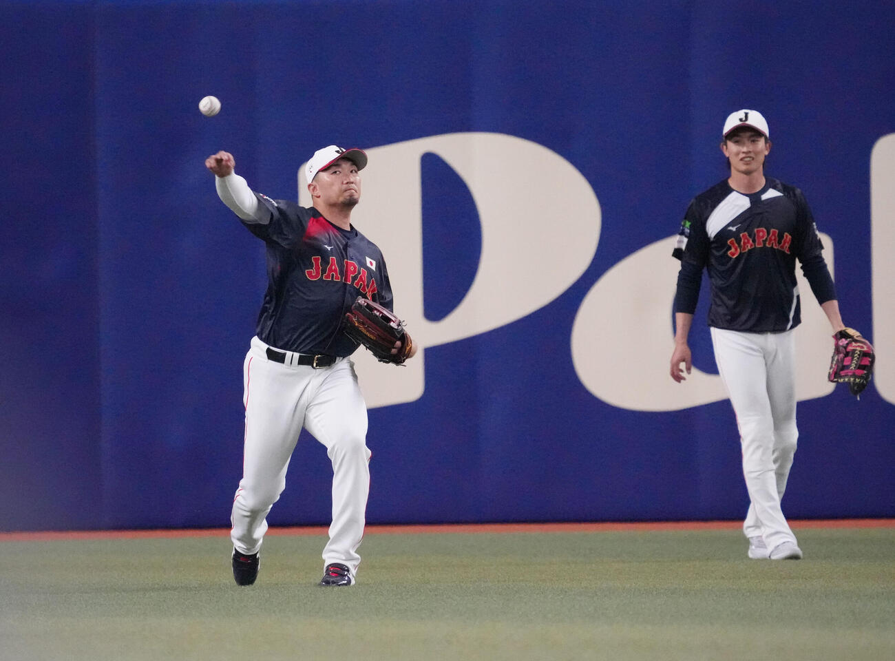 鈴木（左）はシートノックを受け送球する（撮影・森本幸一）