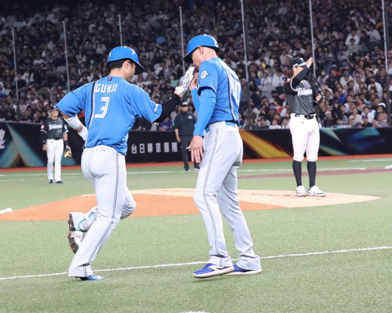 2回先頭で左越えソロを放ち森本コーチとハイタッチする日本ハム郡司（撮影・永野高輔）