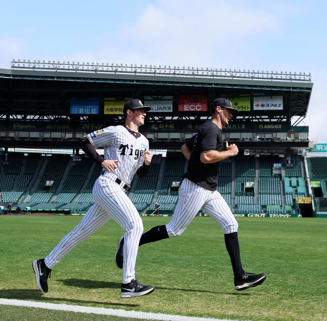 甲子園球場の外野をランニングするルーカス（左）とラグズデール（撮影・加藤哉）