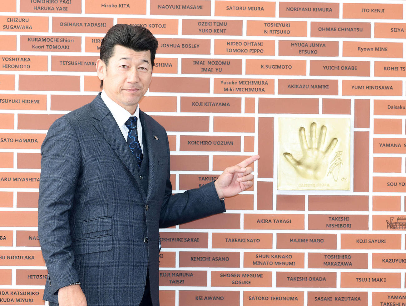 手形の横でポーズを決める三浦アンバサダー（撮影・鈴木正人）　