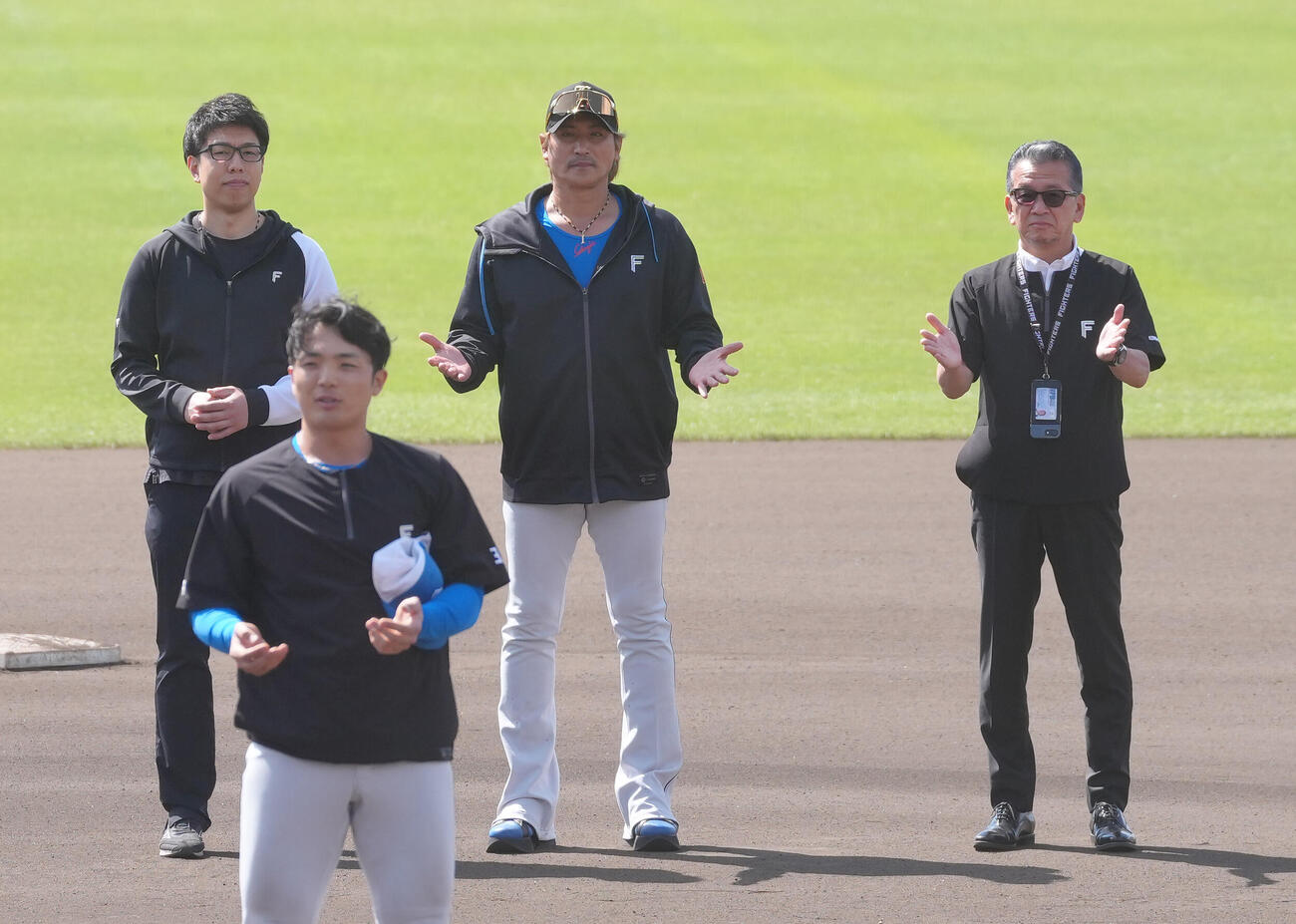 2月24日、日本ハム新庄監督（中央）と並んでキャンプの手締めをする小村球団社長（右）