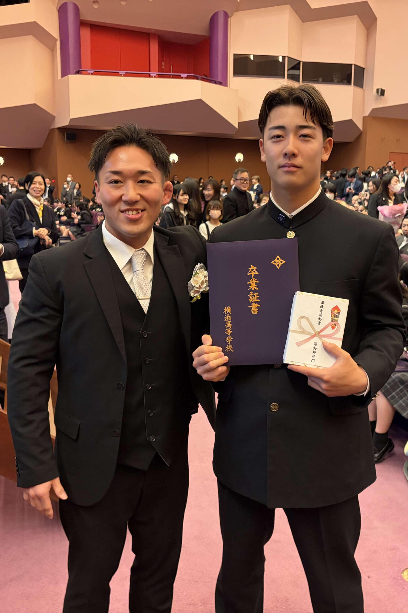 卒業式後のホームルームで担任の立川佑先生（左）から卒業証書を受け取り、記念写真に納まる横浜・奧村頼（撮影・保坂淑子）