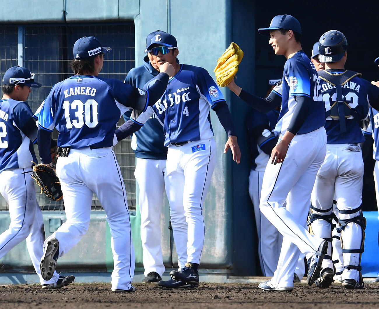ソフトバンク対西武　8回裏、無失点に抑えた冨士（右から2人目）は金子（左から2人目）らナインとタッチを交わしながらベンチへ戻る（撮影・岩下翔太）