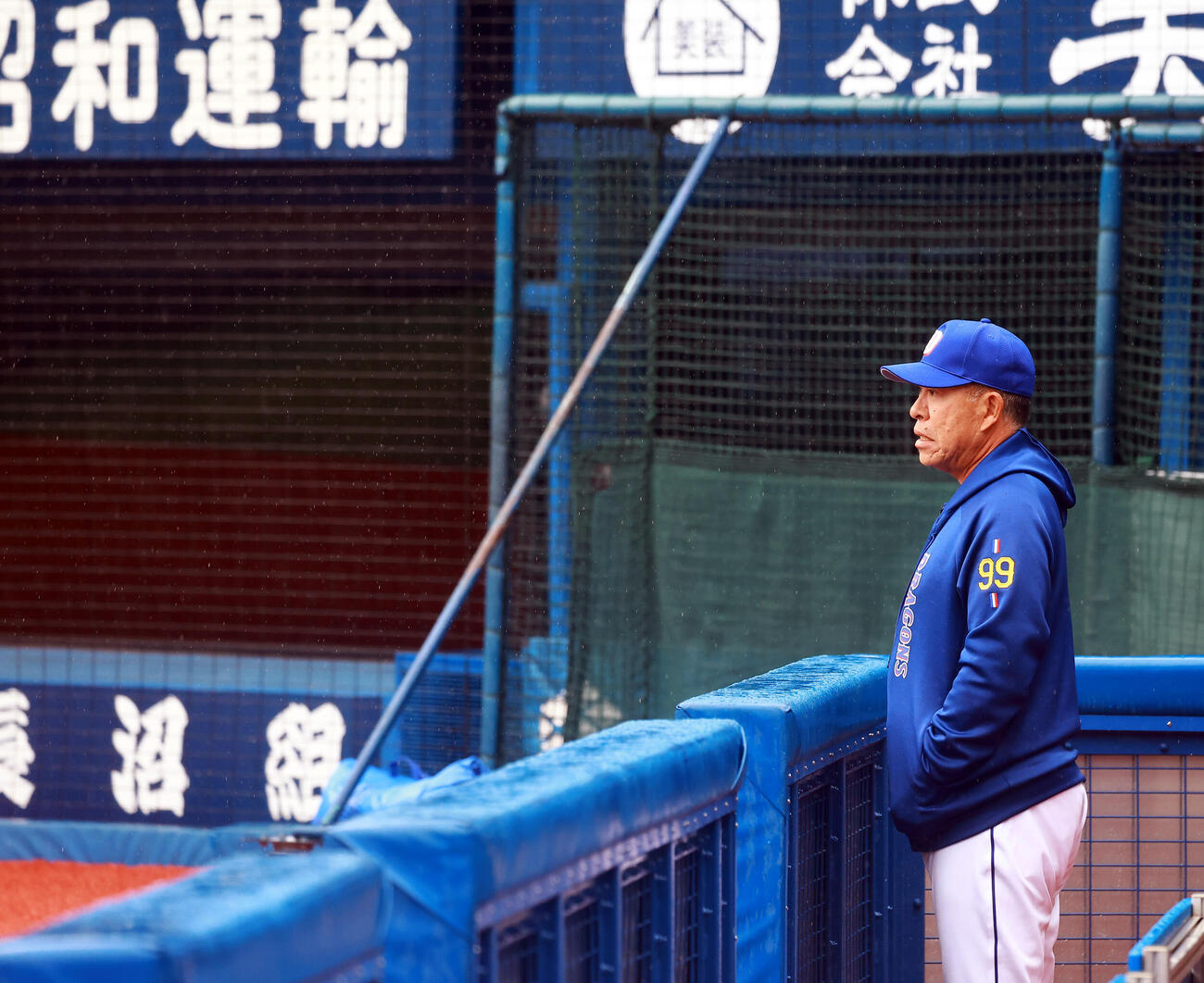 雨の中、グラウンドを見つめる中日井上監督（撮影・野上伸悟）