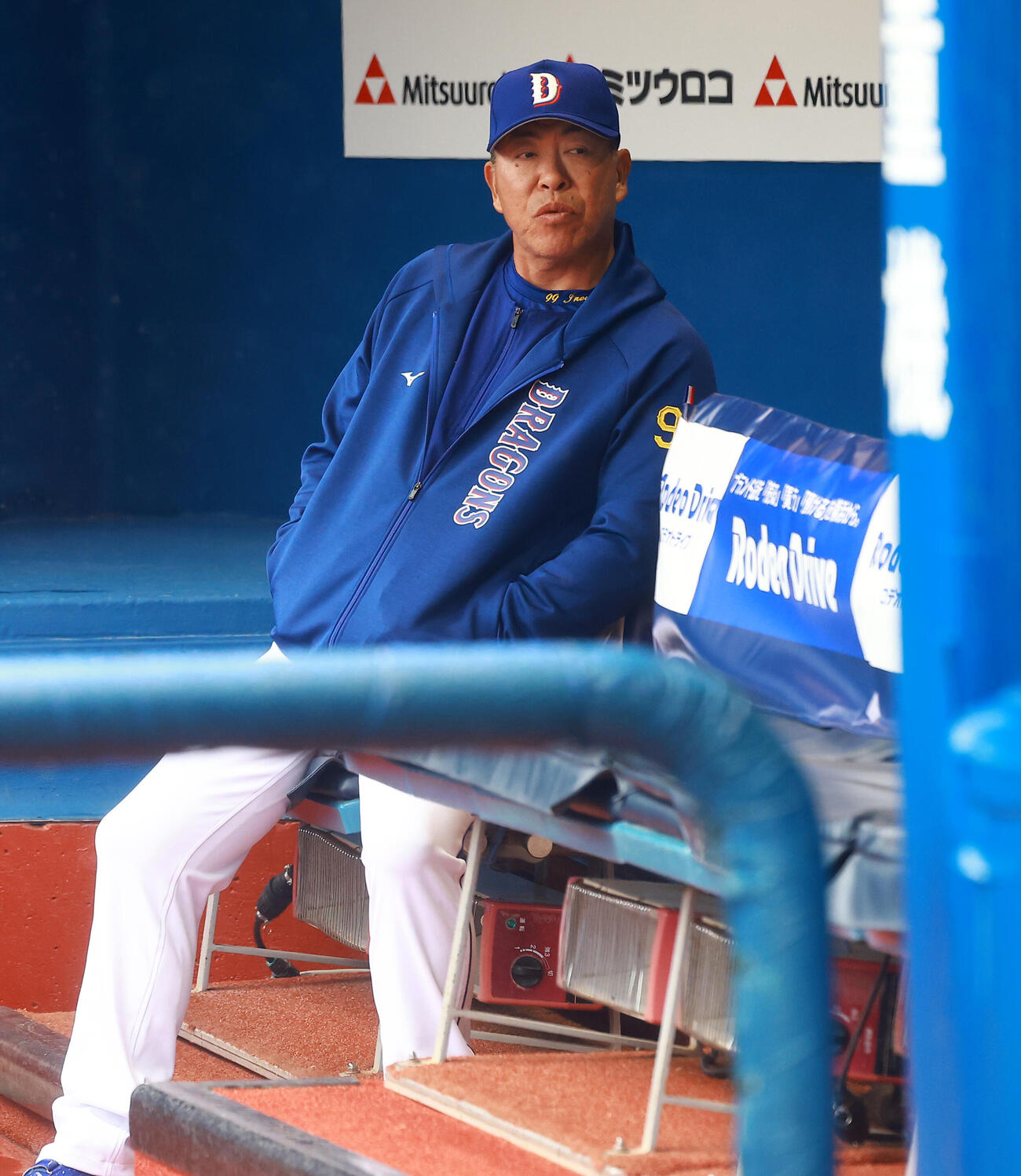 雨の中、ベンチに座る中日井上監督（撮影・野上伸悟）