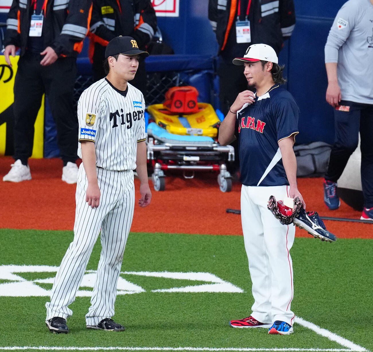 阪神対日本　試合前、伊藤（右）と談笑する阪神伏見（撮影・垰建太）
