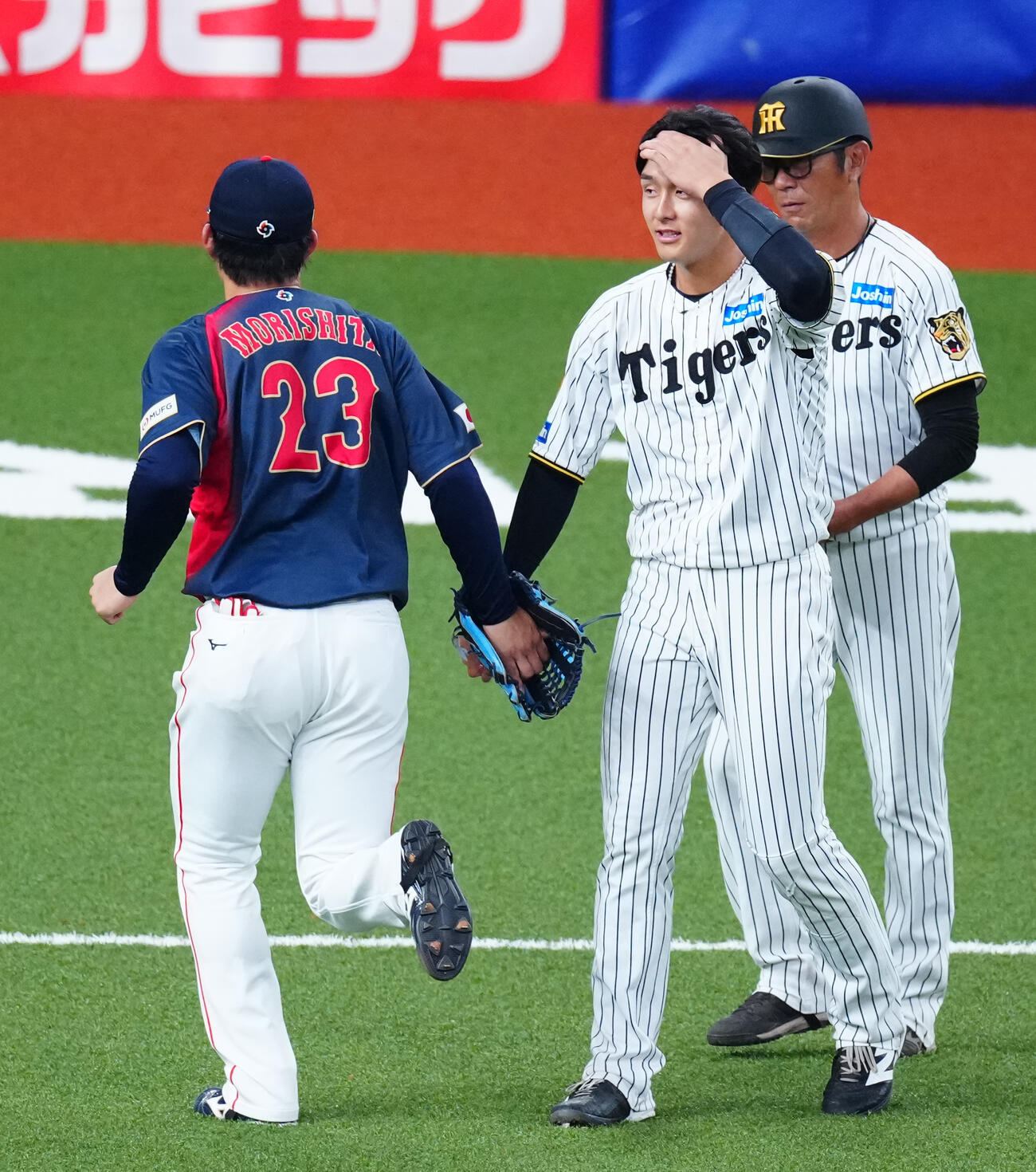 阪神対日本　8回裏の攻撃を終え適時打を放った阪神小幡（右）は森下とすれ違いざまにタッチを交わす（撮影・垰建太）