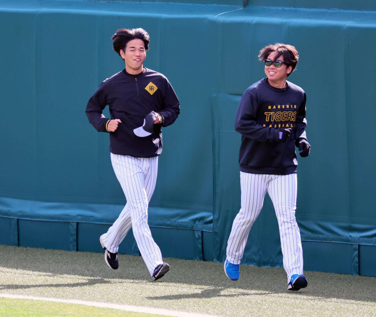 甲子園球場でランニングする阪神高橋（左）と村上（撮影・宮崎幸一）