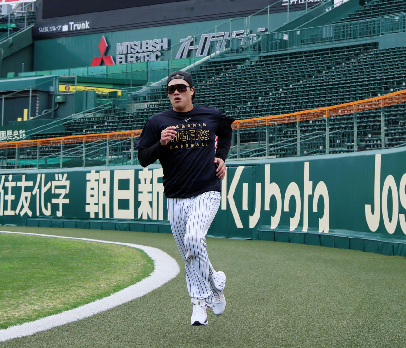 甲子園球場の外野を走る伏見寅威（2026年撮影）