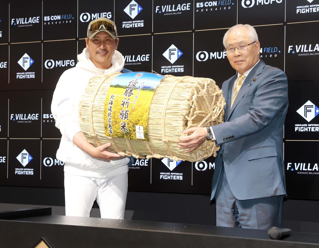 上野北広島市長（右）から優勝祈願米を贈られる新庄監督（撮影・黒川智章）