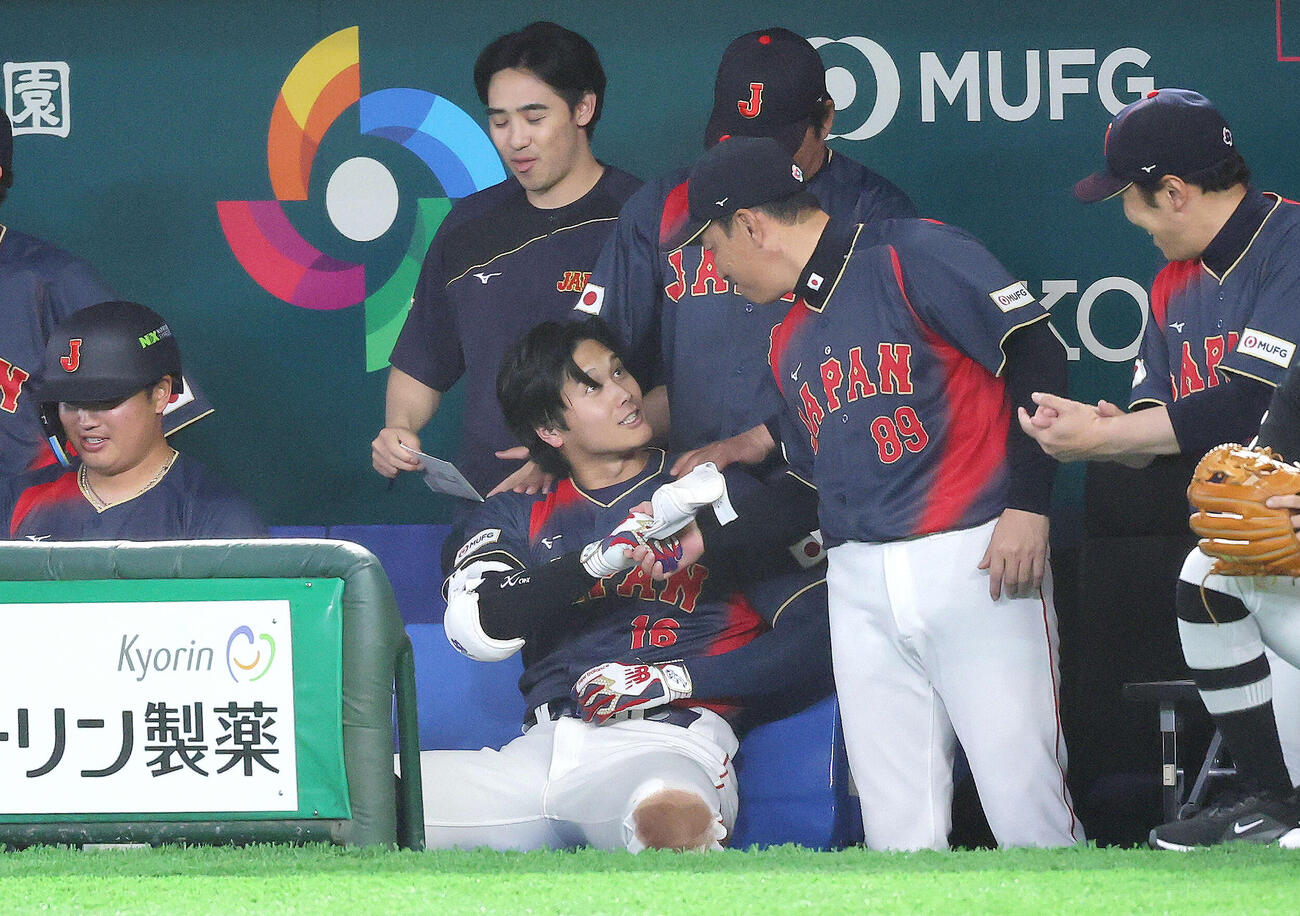 台湾対日本　2回表日本1死満塁、右越え先制満塁本塁打で生還し、井端弘和監督（右）と握手を交わす大谷（撮影・河田真司）
