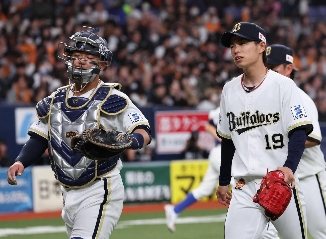 オリックス対巨人　3回に失点したオリックス先発の山岡（右）は森友捕手と話しながらベンチに戻る（撮影・西尾就之）