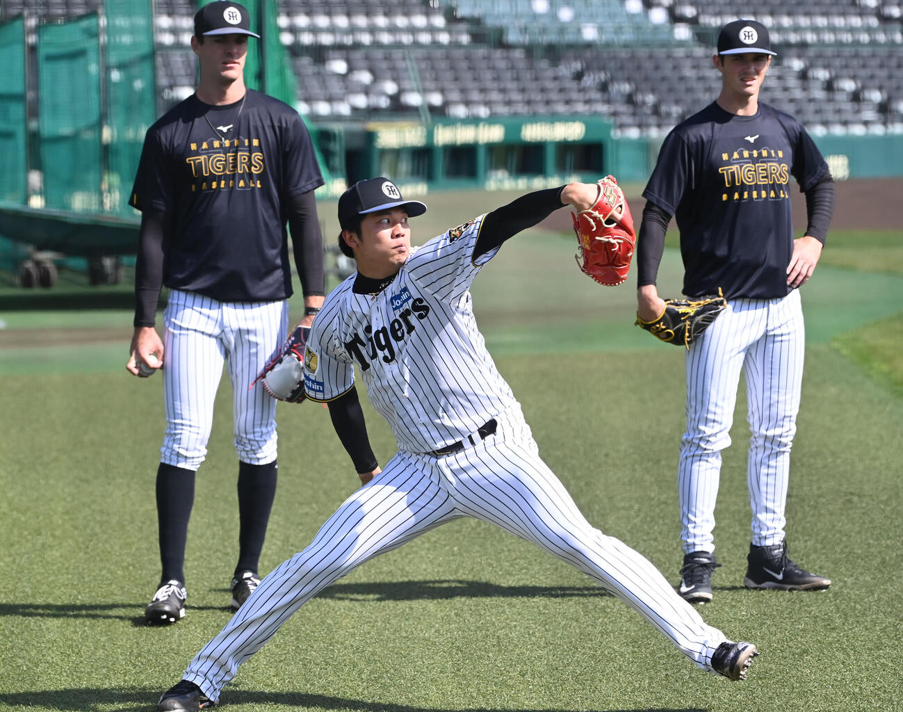 阪神ラグズデール（左）、阪神ルーカス（右）が見守る中、キャッチボールをする阪神才木（撮影・石井愛子）