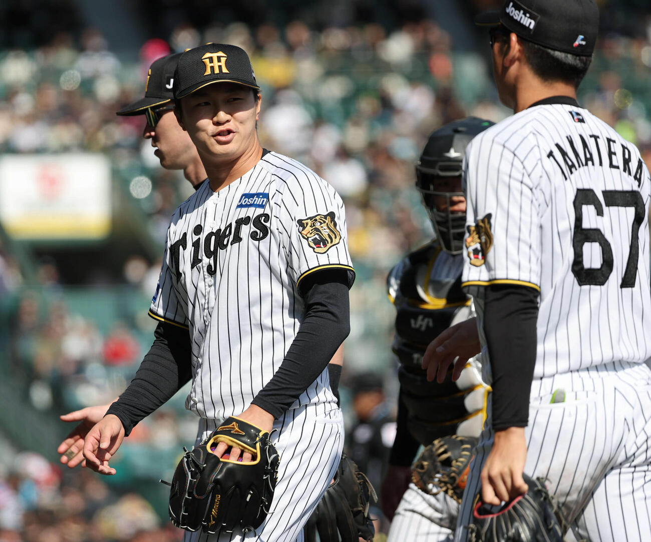 阪神対西武　2年ぶりにオープン戦登板の阪神3番手津田は高寺に声をかけられながらベンチに戻る（撮影・西尾就之）