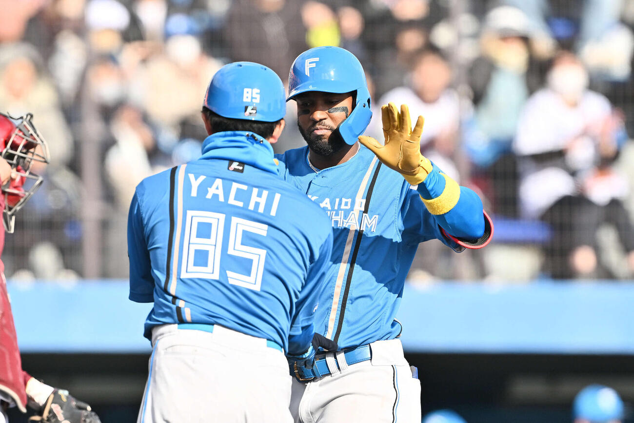 楽天対日本ハム　8回表日本ハム無死一塁、先制2点本塁打を放ったカストロ（右）は生還し谷内コーチとタッチを交わす（撮影・滝沢徹郎）